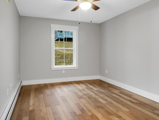 empty room featuring ceiling fan, light wood-type flooring, and baseboard heating