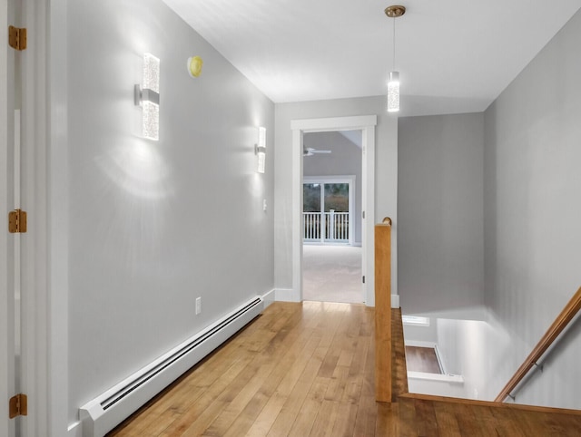 hallway with hardwood / wood-style floors and a baseboard heating unit