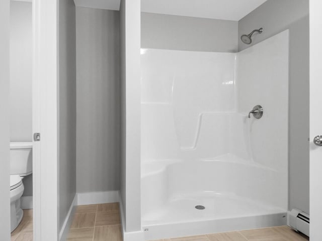 bathroom featuring tile patterned floors, a shower, a baseboard radiator, and toilet