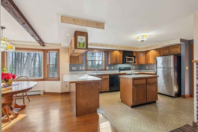 kitchen featuring stainless steel appliances, baseboard heating, sink, beamed ceiling, and a kitchen island