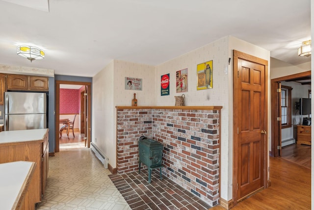 interior space with a wood stove and baseboard heating