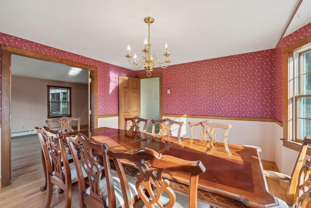 dining room with baseboard heating, hardwood / wood-style floors, plenty of natural light, and a notable chandelier