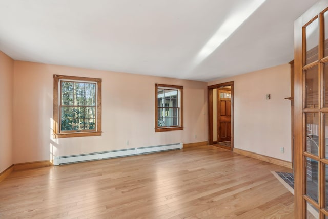 spare room with light wood-type flooring and a baseboard heating unit