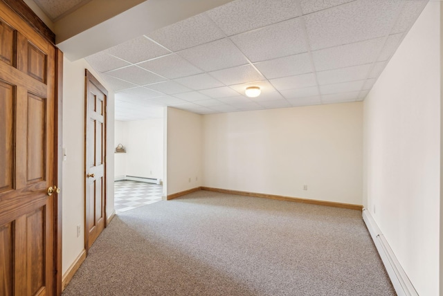 unfurnished room with a paneled ceiling, carpet floors, and a baseboard radiator