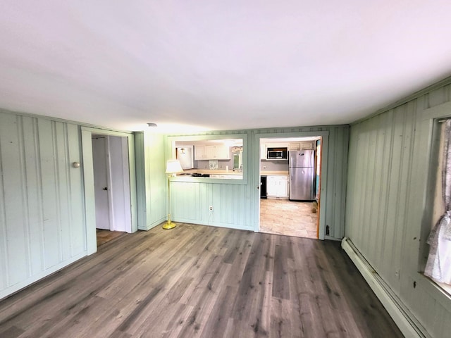 unfurnished living room with hardwood / wood-style flooring and a baseboard radiator