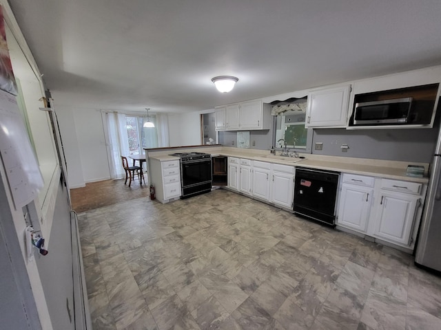 kitchen with kitchen peninsula, white cabinetry, sink, and black appliances