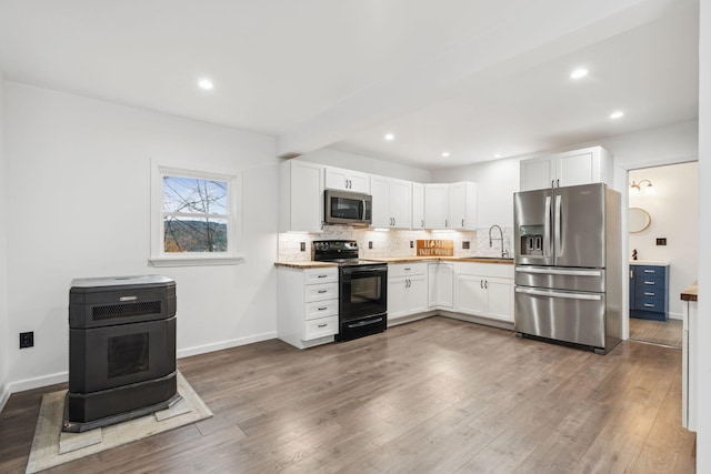 kitchen with white cabinets, appliances with stainless steel finishes, dark wood-type flooring, and sink