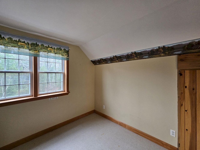 bonus room with lofted ceiling, baseboards, and light colored carpet