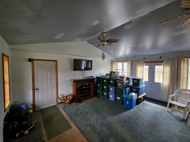 living area featuring a fireplace, lofted ceiling, and a ceiling fan