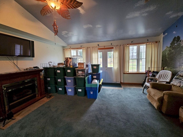 carpeted living area with a ceiling fan and vaulted ceiling