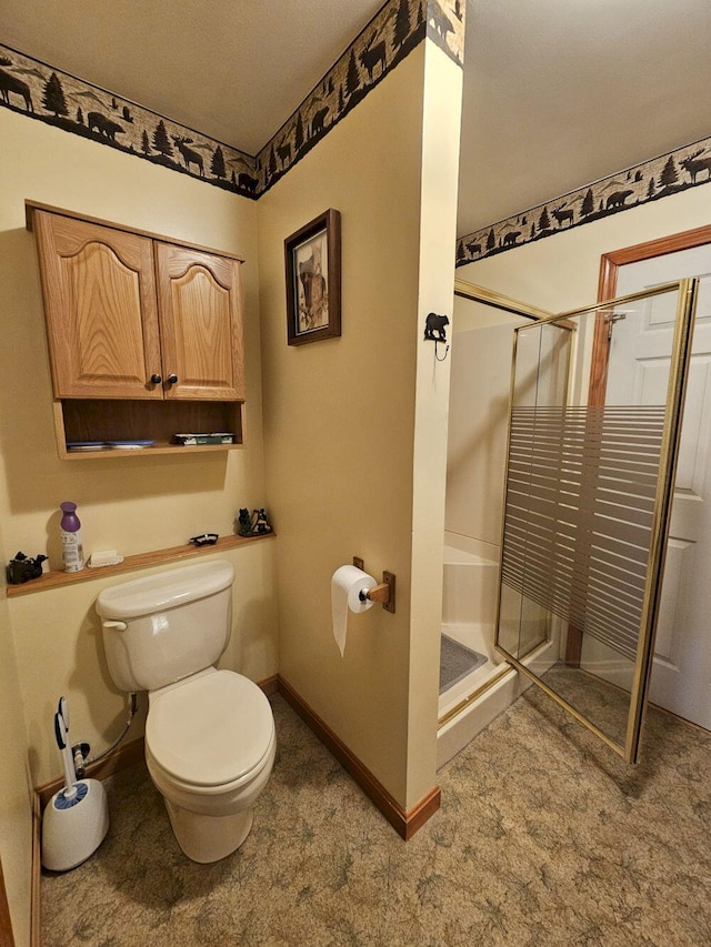 full bathroom with toilet, baseboards, and a shower stall