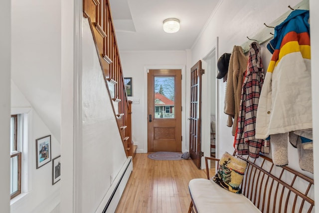 doorway with stairway, ornamental molding, light wood finished floors, and a baseboard radiator