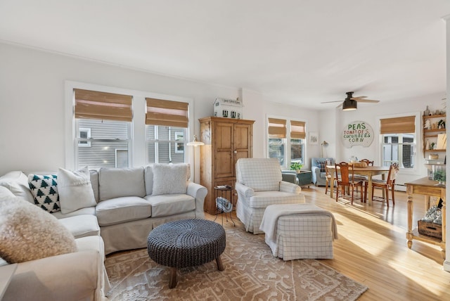 living area featuring light wood-style floors and a ceiling fan