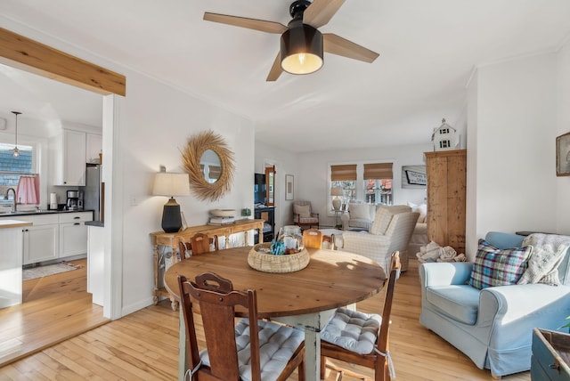 dining area with light wood-style floors and ceiling fan