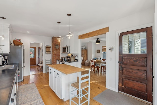 kitchen featuring a sink, appliances with stainless steel finishes, light wood-style flooring, and white cabinets