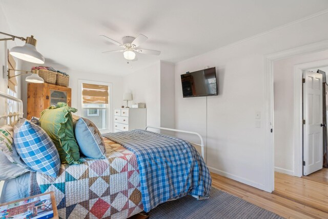 bedroom featuring ornamental molding, wood finished floors, cooling unit, baseboards, and ceiling fan