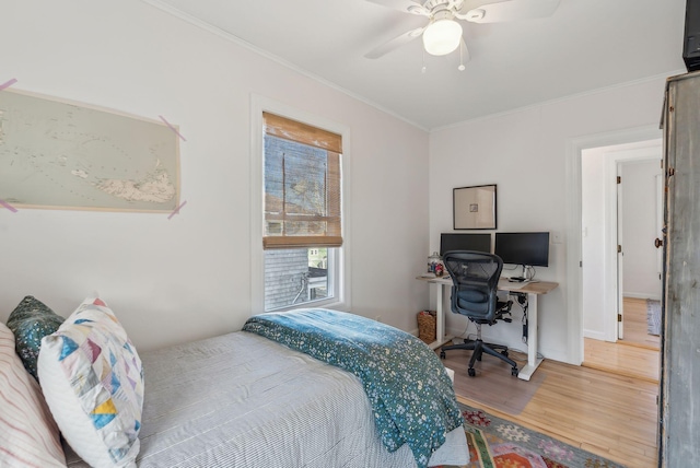 bedroom featuring a ceiling fan, wood finished floors, and crown molding