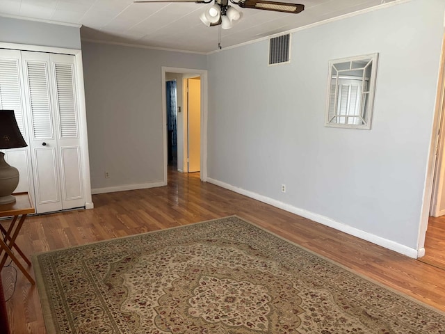 unfurnished bedroom with hardwood / wood-style floors, ceiling fan, and ornamental molding