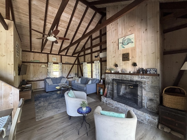 70 Hall Quarry Rd, Mount Desert, ME 04660 - living area featuring a fireplace, wooden walls, a ceiling fan, wood finished floors, and wooden ceiling with exposed beams