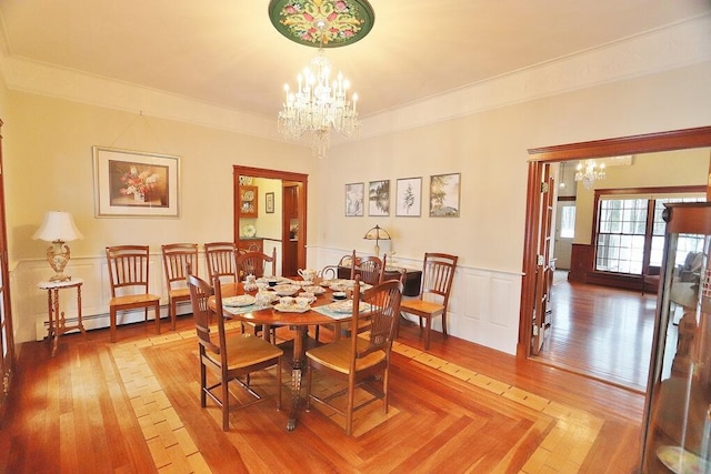 dining space with baseboard heating, ornamental molding, and an inviting chandelier