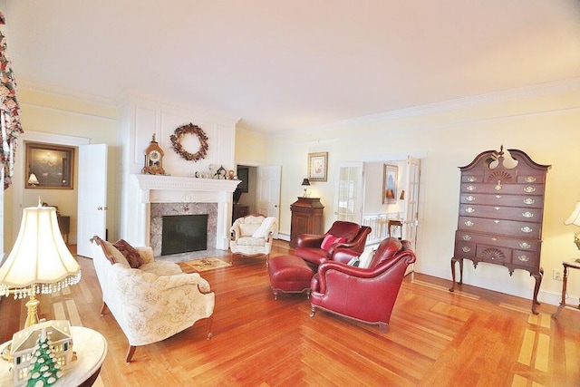 living room with hardwood / wood-style flooring, crown molding, and a fireplace