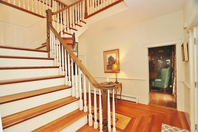 staircase featuring a baseboard radiator and parquet floors