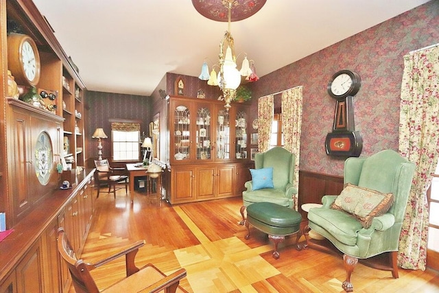 sitting room with built in features, a chandelier, and light hardwood / wood-style floors