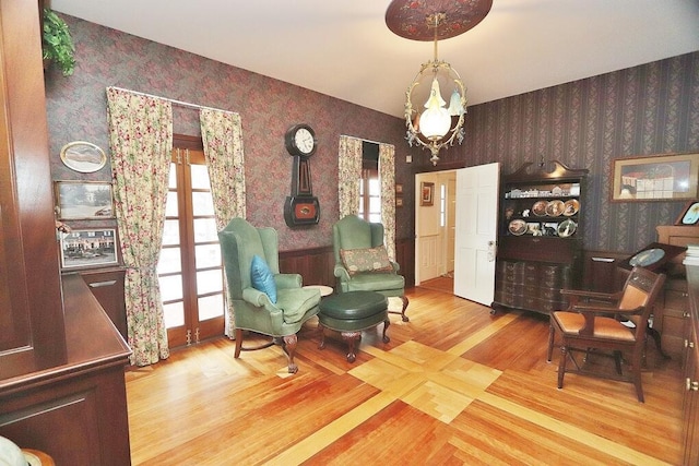 living area with an inviting chandelier, light hardwood / wood-style flooring, and a healthy amount of sunlight