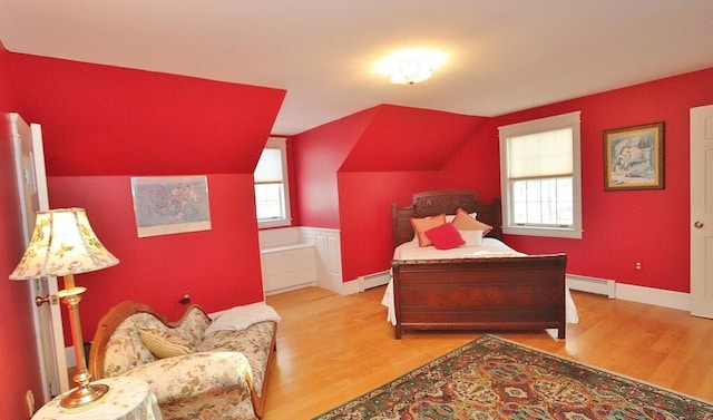 bedroom with light hardwood / wood-style floors, lofted ceiling, and a baseboard radiator