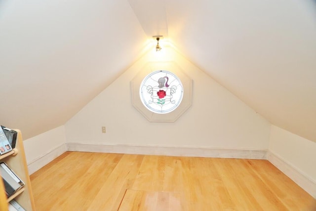 bonus room with hardwood / wood-style flooring and vaulted ceiling