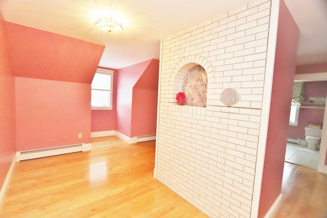 additional living space featuring hardwood / wood-style flooring, baseboard heating, and vaulted ceiling