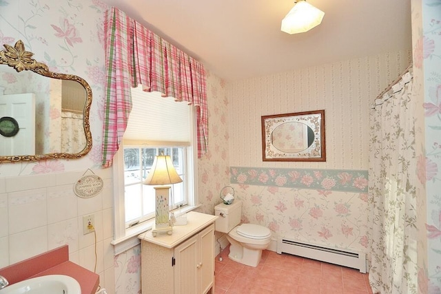 bathroom featuring baseboard heating, sink, tile patterned flooring, and toilet