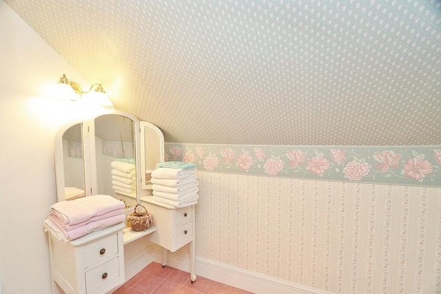 bathroom featuring tile patterned floors and lofted ceiling