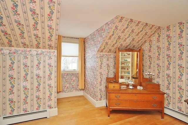 unfurnished bedroom with light hardwood / wood-style flooring and a baseboard radiator