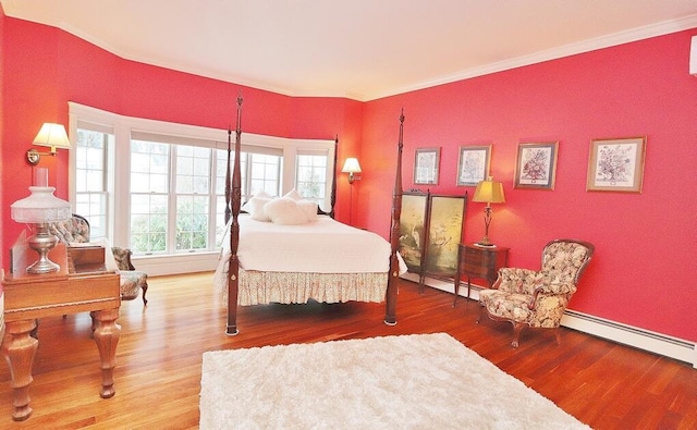 bedroom with baseboard heating, wood-type flooring, and ornamental molding