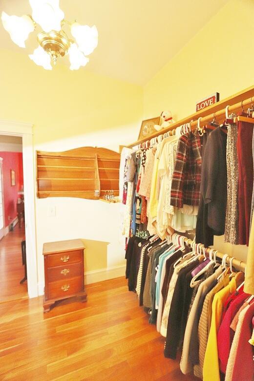 spacious closet with light hardwood / wood-style flooring and a notable chandelier