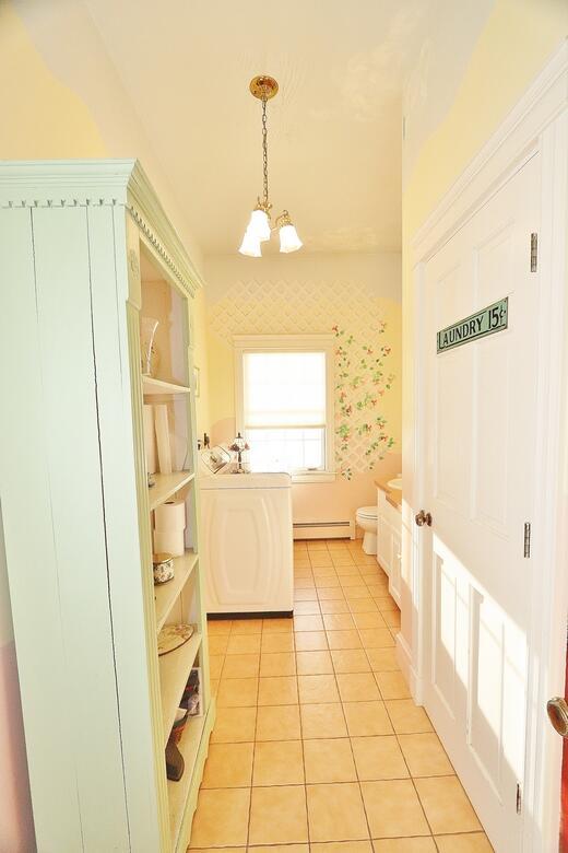 washroom featuring washer / clothes dryer, an inviting chandelier, light tile patterned flooring, and a baseboard heating unit