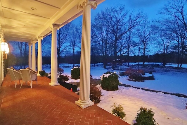 snow covered patio featuring a porch