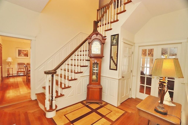 stairway featuring french doors and high vaulted ceiling