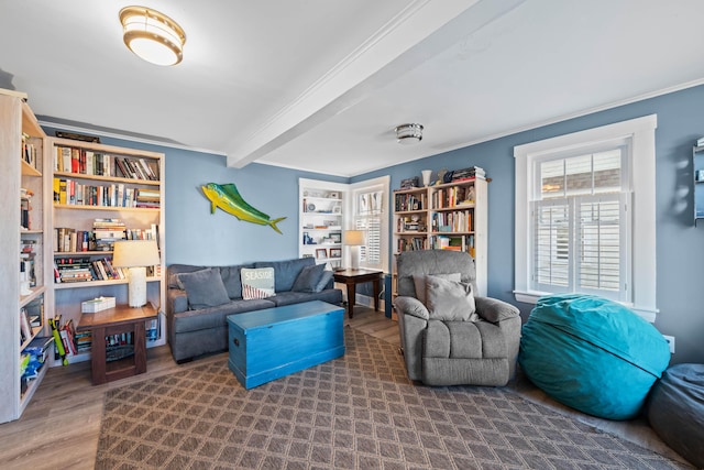 living room with beam ceiling, wood-type flooring, built in features, and ornamental molding