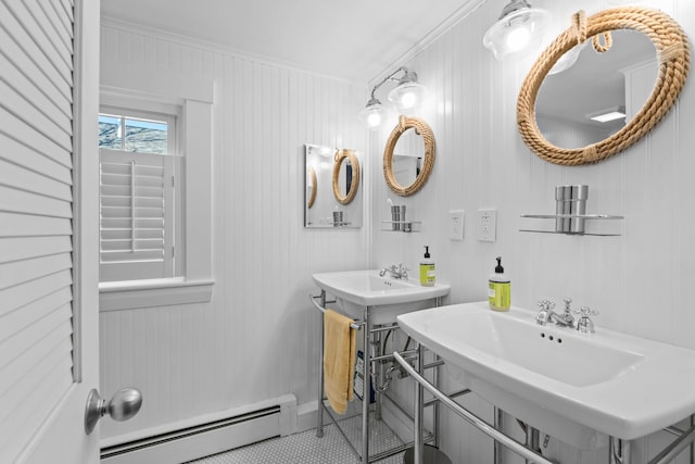 bathroom with dual sinks, ornamental molding, baseboard heating, wooden walls, and tile patterned flooring