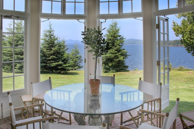 sunroom featuring a water view