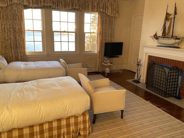 399 Hermits Point Rd, Islesboro, ME 04848 - bedroom with baseboard heating, a brick fireplace, and wood finished floors