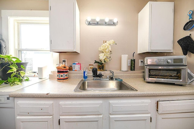 kitchen featuring white cabinetry and sink