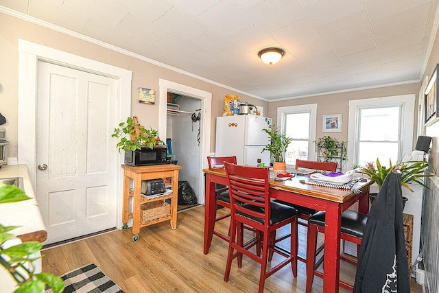 dining area featuring light hardwood / wood-style floors and crown molding