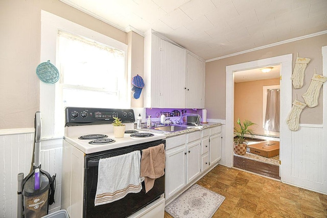 kitchen featuring white cabinets, electric stove, sink, and ornamental molding