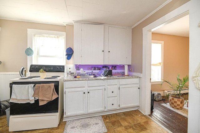 kitchen with electric range, crown molding, white cabinetry, and sink