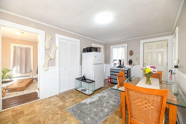 kitchen with white refrigerator, ornamental molding, and a baseboard radiator