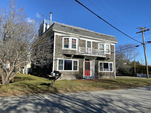 view of front of home featuring a balcony and a front yard