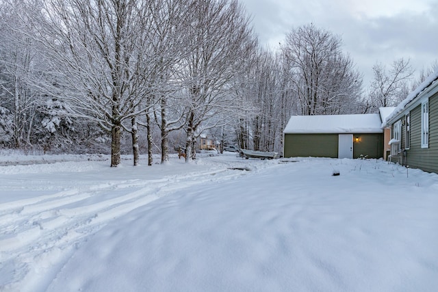 yard covered in snow with an outbuilding